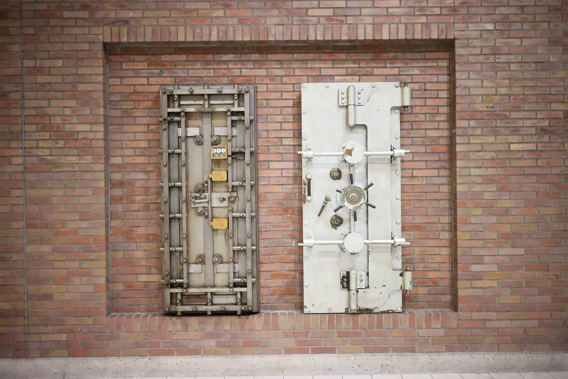 Heavy steel bank vault doors set into a brick wall
