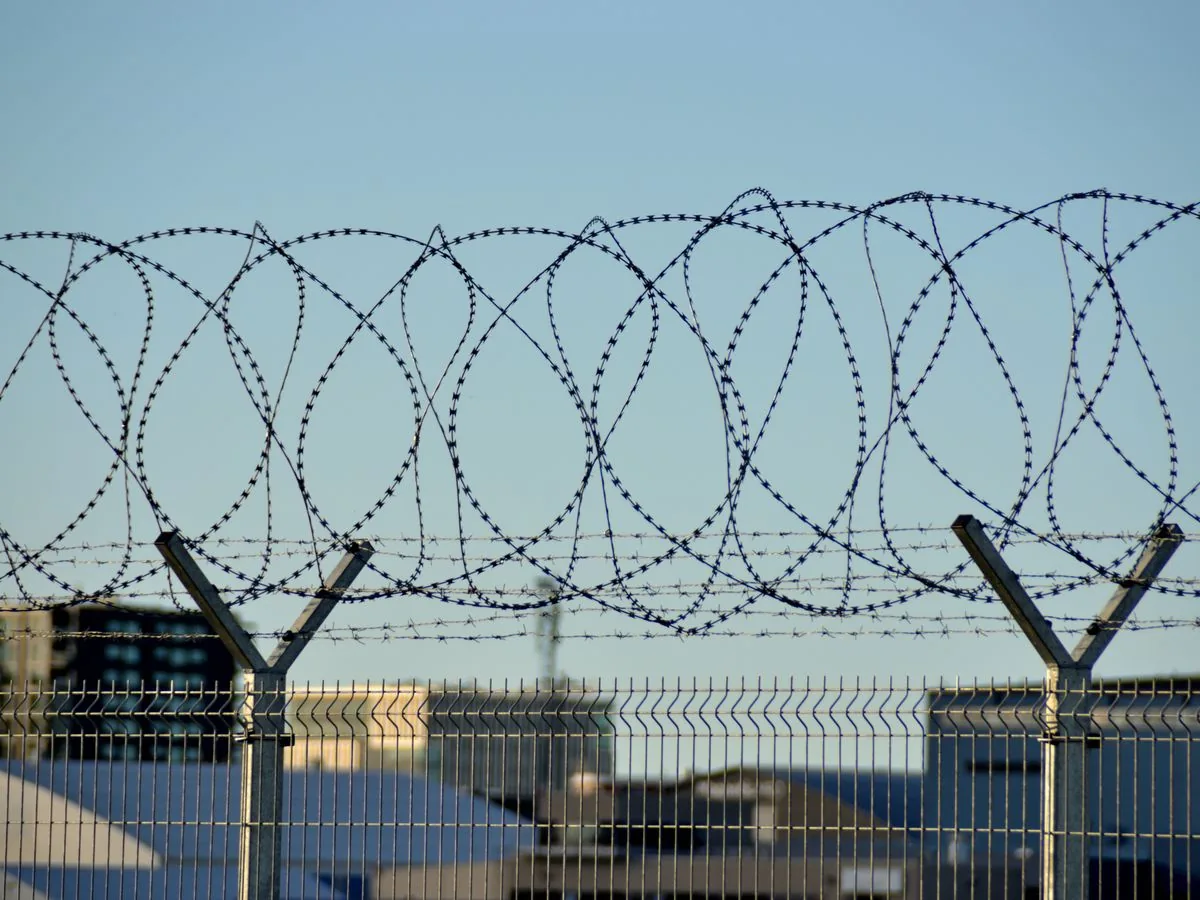 Secured government and defense facility perimeter with barbed-wire fencing